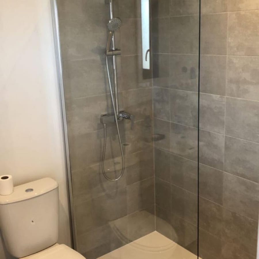 Douche avec paroi de verre et carrelage gris grand format